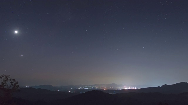 延时4k视频。泰国南邦梅莫，在迷雾笼罩的夜空中，长时间曝光的山上，星星排列(土星、月亮、金星、木星)的现象。视频素材