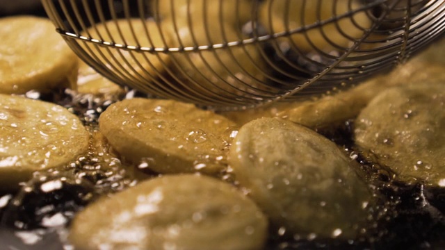 把腊肠放在装满油的锅里炸。点心时间。快餐。街头食品。缓慢的运动。近距离视频素材