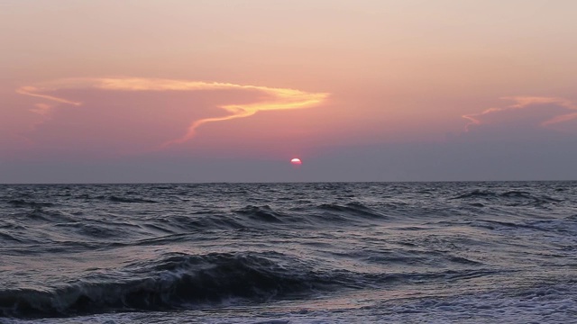 海景傍晚时分伴夕阳，海浪在海面上。视频素材