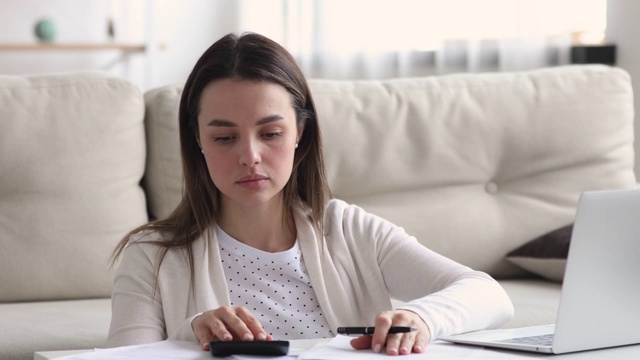 手持纸质银行收据计算税金或账单的千禧一代女性视频素材