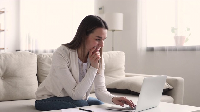 快乐的千禧女用户在家里用笔记本上网视频素材