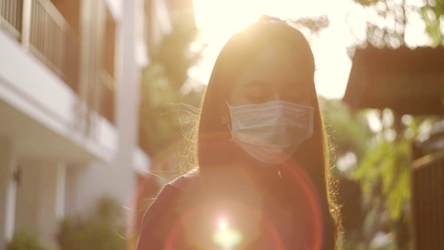 亚洲妇女戴着面具走路，并学会看风景。视频素材