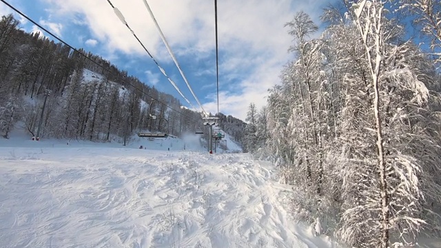 滑雪场滑雪缆车在雪坡上的视角运动。在冬季滑雪场，人们骑着滑雪板和滑雪板下坡，速度加快。Timelapse山冬季度假缆车。视频素材