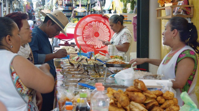 在墨西哥瓦哈卡市场出售熟食的妇女视频素材