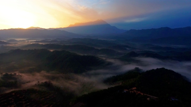 在婆罗洲沙巴州热带雨林中，以基纳巴卢山为背景的4k空中镜头美丽的日出视频素材