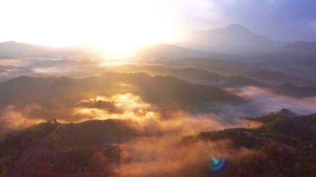 在婆罗洲沙巴州热带雨林中，以基纳巴卢山为背景的4k空中镜头美丽的日出视频素材