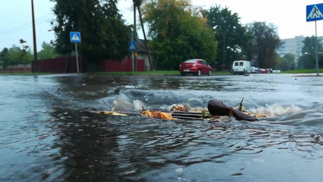 下雨时，水从道路排水沟流入雨水沟下水道收集器。主要渠道的排水网络。城市里的雨天。恶劣和危险的交通条件视频素材