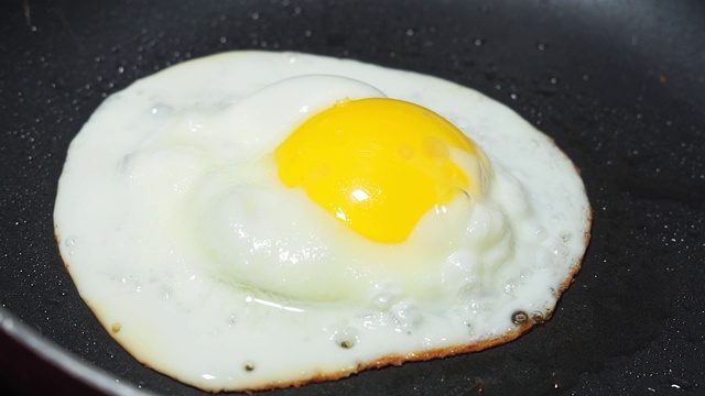 特写:用小煎锅煎鸡蛋。准备早餐视频素材