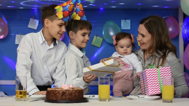 两个男孩祝贺妈妈和宝宝的生日，并赠送礼物视频素材