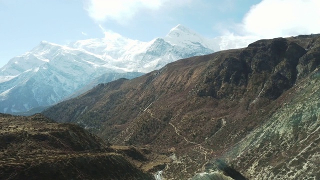 尼泊尔喜马拉雅山马南谷的全景照片。山谷里有一条小河。高山。贫瘠的山坡，中间有一些灌木丛。安纳普尔纳峰电路长途跋涉视频素材