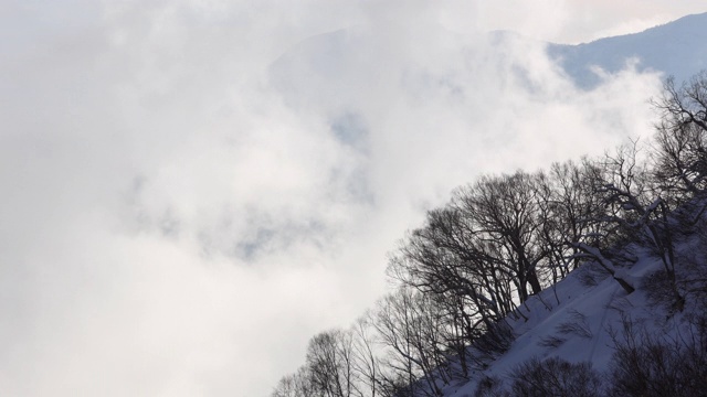 日本阿尔卑斯山晴天到雾，白雪皑皑的风暴云天气变化在冬季雪山背景时间推移视频素材