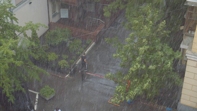 拍摄于夏季白天城市街道上的雨中视频素材