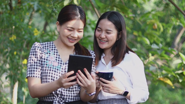 两个亚洲女人喝咖啡和愉快的女人闲谈在咖啡馆视频素材