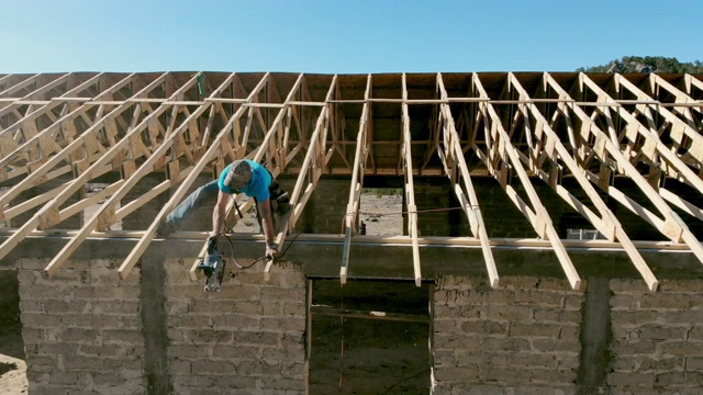 在新建筑的屋顶上工作的木匠视频素材