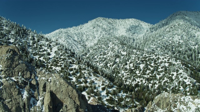 阳光照耀在圣加布里埃尔山脉的雪坡上-空中视频素材