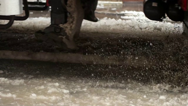 一辆汽车在洪水中被溅到。雨天在城市道路上行驶的汽车。缓慢的运动。视频素材