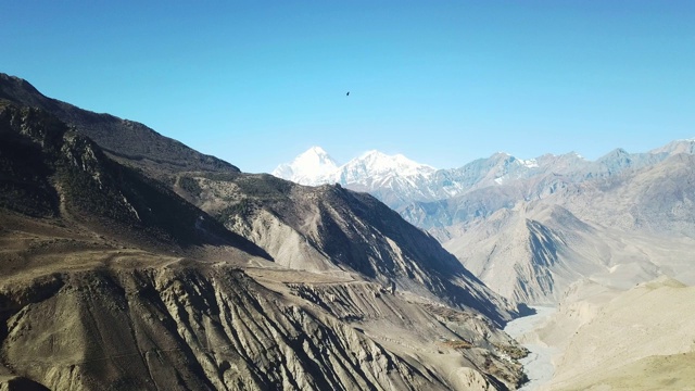 尼泊尔喜马拉雅山马南谷的全景照片。山谷里有一条小河。高山。贫瘠的山坡，中间有一些灌木丛。安纳普尔纳峰电路长途跋涉视频素材