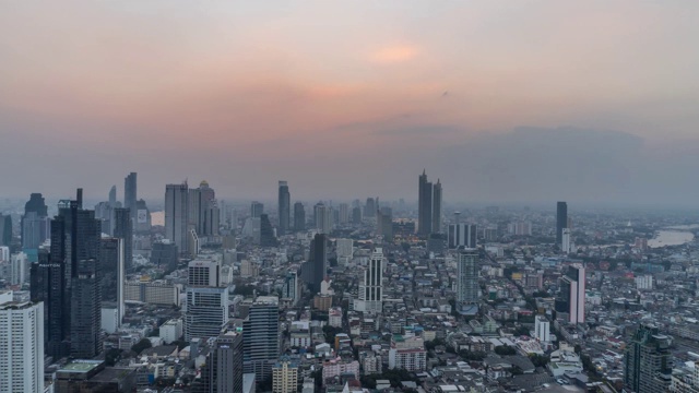 4K白天到夜晚的日落场景在曼谷市中心的现代写字楼和公寓，日落的天空和云彩在曼谷，泰国。视频素材