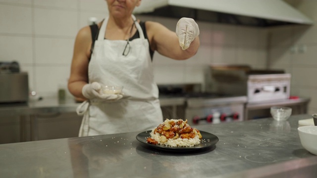 厨师在厨房里给饭菜加芝麻视频素材