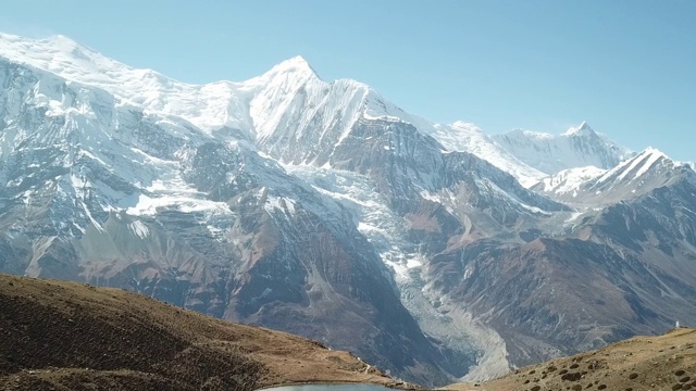 冰湖，作为Annapurna环路徒步旅行的一部分，喜马拉雅山，尼泊尔。安纳布尔链子在后面，上面覆盖着雪。晴朗的天气，干燥的草地，雪峰。自由、放松。高海拔湖泊。视频素材