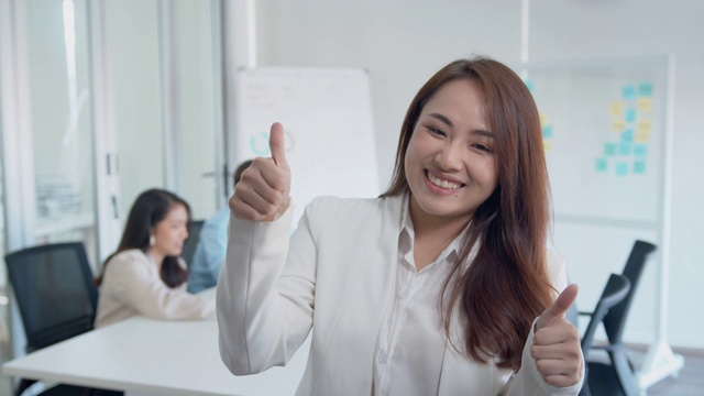 自信的亚洲女商人在同事面前竖起大拇指视频素材