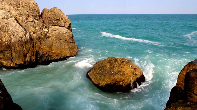 蓝色的海浪撞击着岩石。阳光明媚的夏日海浪景观视频素材