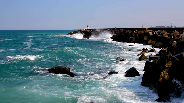 海浪冲击着防波堤。阳光明媚的夏日海浪景观视频素材