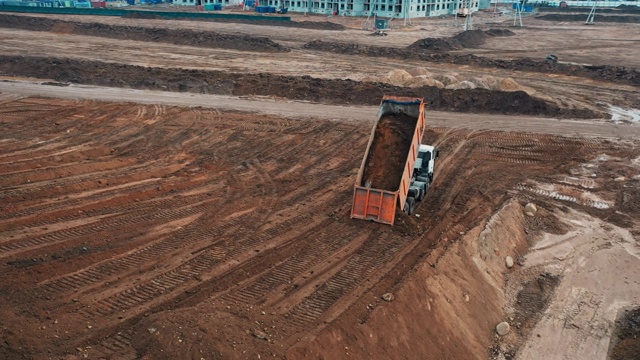 无人机对采石场的俯视图，从沙卡车拖拉机泄漏的沙砾，用于建设一个公寓面板房屋建设视频素材