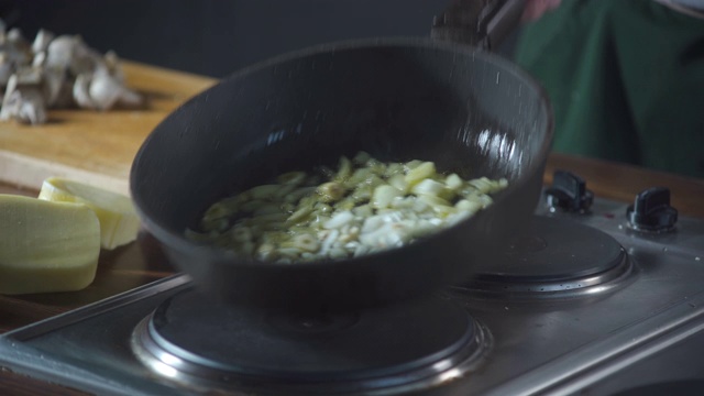 专业厨师在餐厅用平底锅炒洋葱和大蒜。在烹饪食物。健康营养的美食厨房。做顿饭。准备吃的食物。美味的菜。做饭吃。视频素材