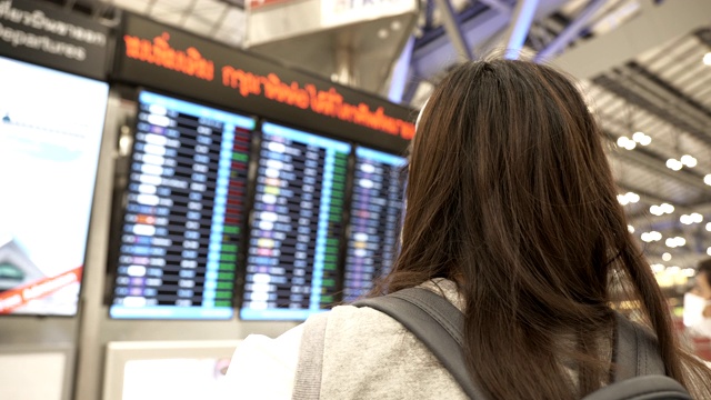 一名亚洲女子戴着防护面罩，站在飞机前检查飞机视频素材