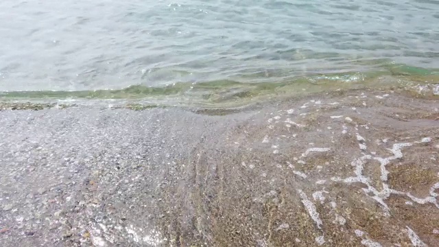 海浪拍打着卵石。海上冲浪。海浪冲击着岸边的卵石。夏日海滨度假概念视频素材