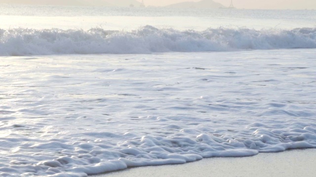 慢镜头:海滩上的浪花泡沫。视频素材