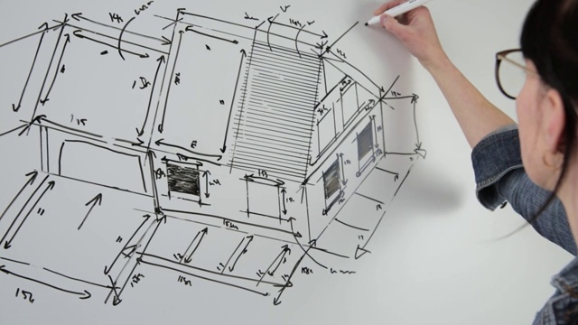 一个年轻的女建筑师为一个新的家庭项目草图的特写。技术图纸的工作概念视频素材