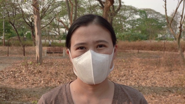 戴着医用口罩的女人看着摄像机视频素材