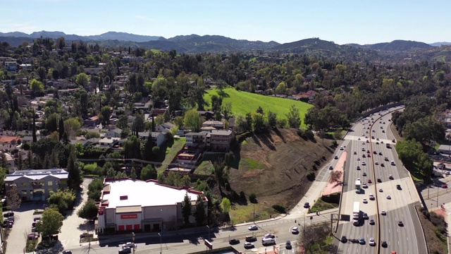 空中拍摄的车辆在城市道路上移动在阳光明媚的一天-林地山，加利福尼亚视频素材