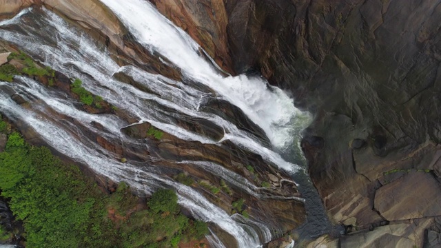 从空中拍摄的水从山上的岩石倾泻到下面的河里——西班牙Xallas视频素材