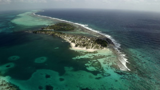 鸟瞰海浪拍打海岸的岛屿，无人机飞过海滩-可可梅礁，伯利兹视频素材