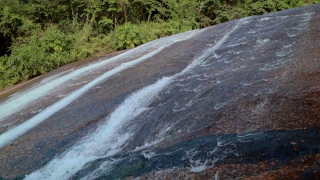 低角度的水流动的岩石在森林- Ilhabela，巴西视频素材