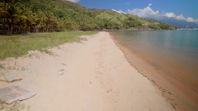 在阳光明媚的日子里，依山而建的海滩、陆地和海上的树木——巴西的伊尔哈贝拉视频素材