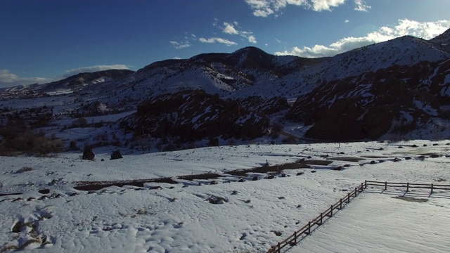 鸟瞰图的白色白雪覆盖的景观对天空，风景的山与无人机向前移动- Genesee，科罗拉多州视频素材