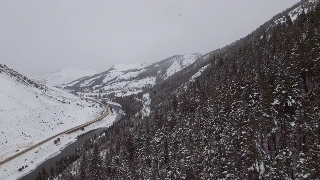 积雪覆盖的常青树鸟瞰图的河流和高速公路，冬季景观对天空-杰克逊，怀俄明州视频素材