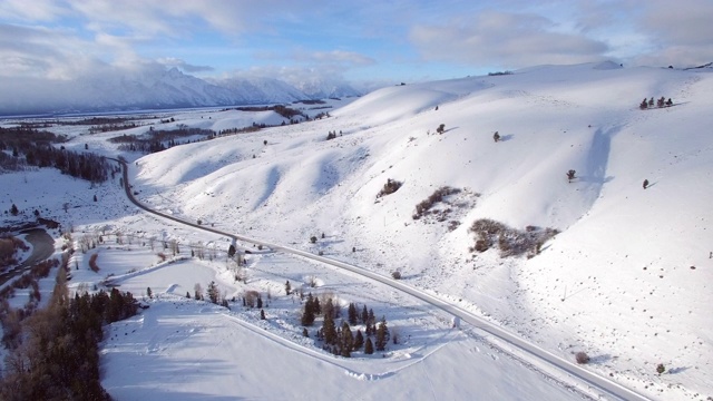 鸟瞰图上的树在雪山对天空，田园诗般的美丽的白色风景-杰克逊，怀俄明州视频素材