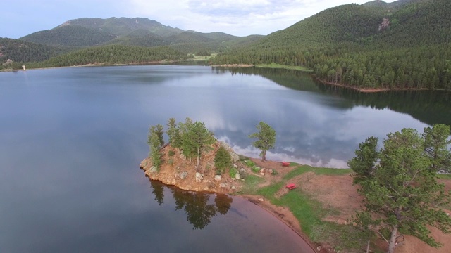 鸟瞰图美丽平静的湖由绿树对山，反映在水附近的森林-湖惠灵顿，科罗拉多州视频素材