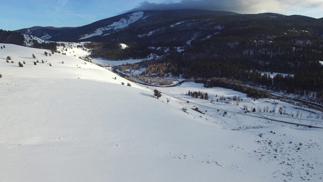 鸟瞰图的雪山与河流在山谷，无人机向前移动与森林美丽的景观-杰克逊，怀俄明州视频素材