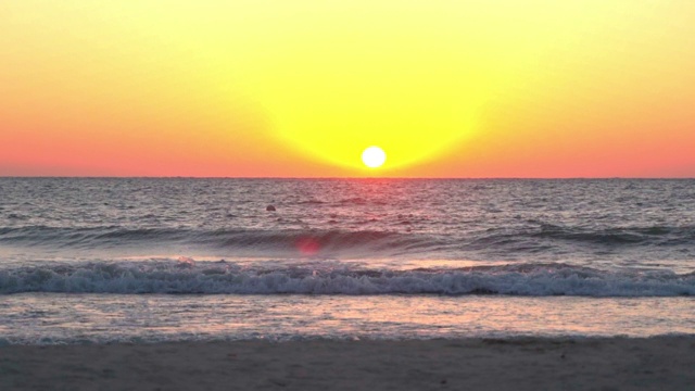 美丽的海浪在海滩上溅起浪花，在橙色的天空下，夕阳照耀着海景-蒙特哥湾，牙买加视频素材