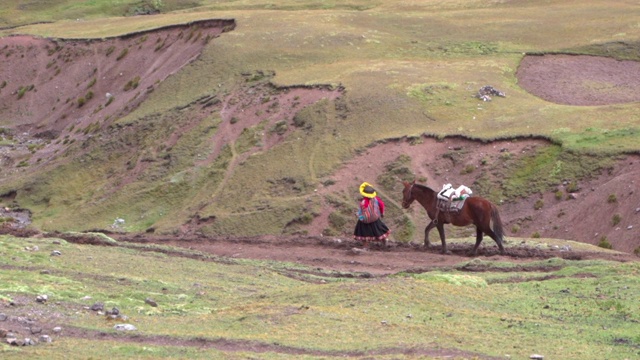 慢动作的秘鲁妇女走在山路上的马，人们徒步下山-彩虹山，秘鲁视频素材