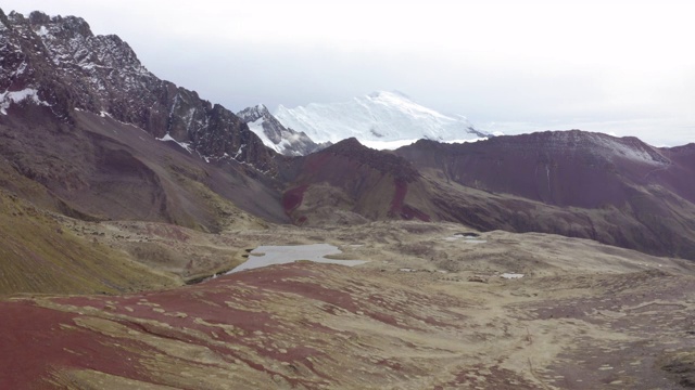 航拍田园诗般的岩石山脉对多云的天空，无人机从贫瘠的景观向后移动-彩虹山，秘鲁视频素材