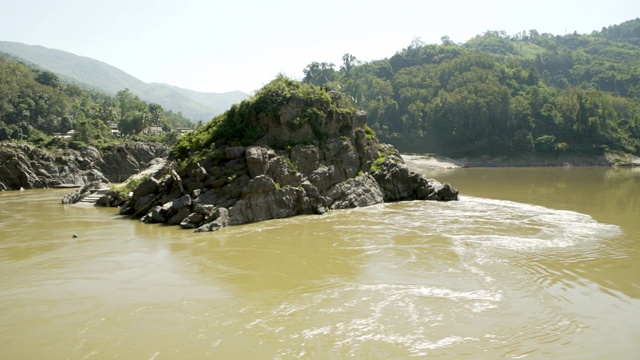 在阳光明媚的日子里，泰国清莱，在河边的天空中拍摄岩石和山脉视频素材