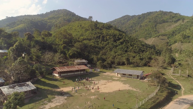 空中拍摄的村民在绿色的山，无人机向后飞行山谷在阳光明媚的一天-湄公河，老挝视频素材