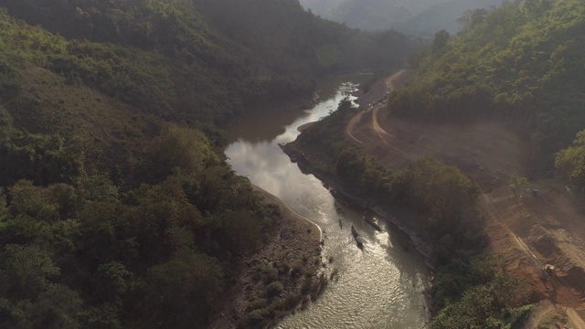 航拍的河流弯曲在山谷附近的道路，无人机飞向树木和山脉-湄公河，老挝视频素材